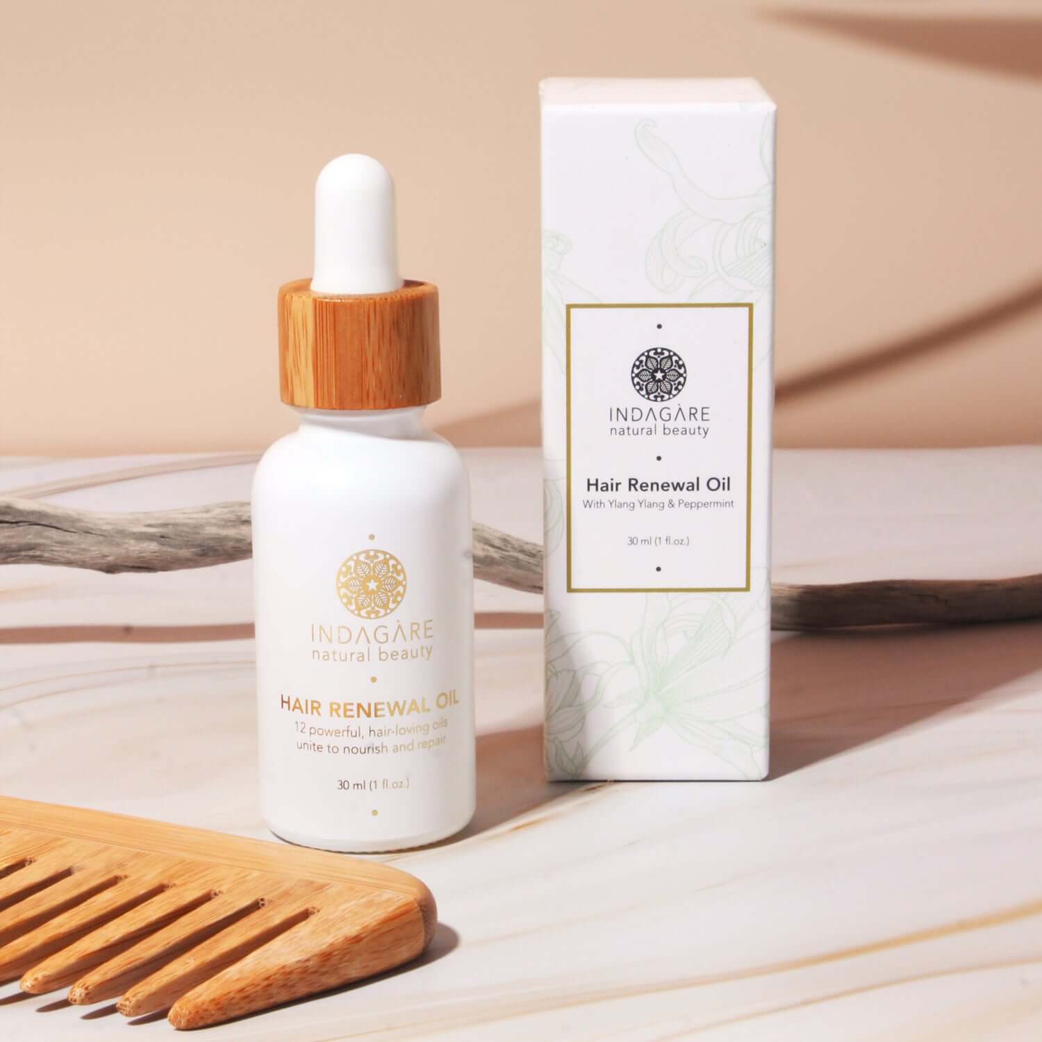 Indagare's Organic Hair Renewal Oil displayed on a bench with hair comb