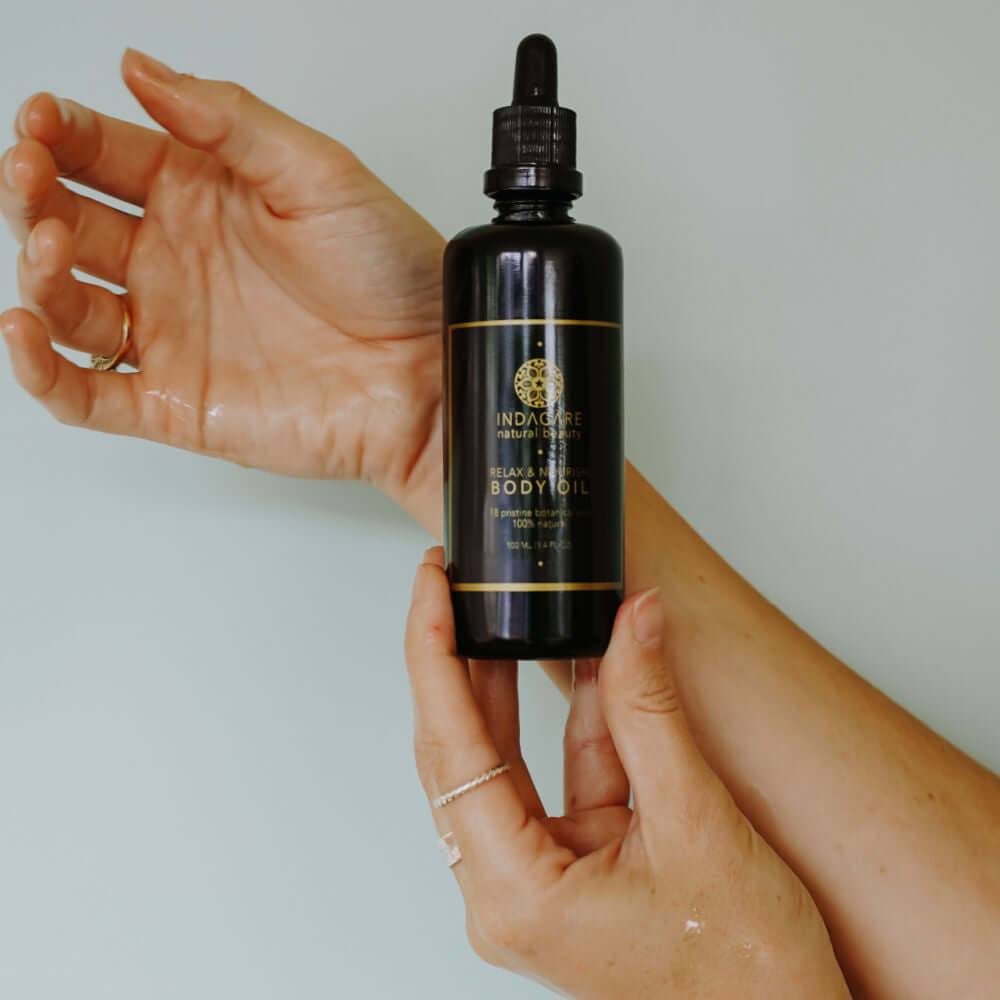 Woman holding Repair and Nourish Organic Body Oil in her hand hand