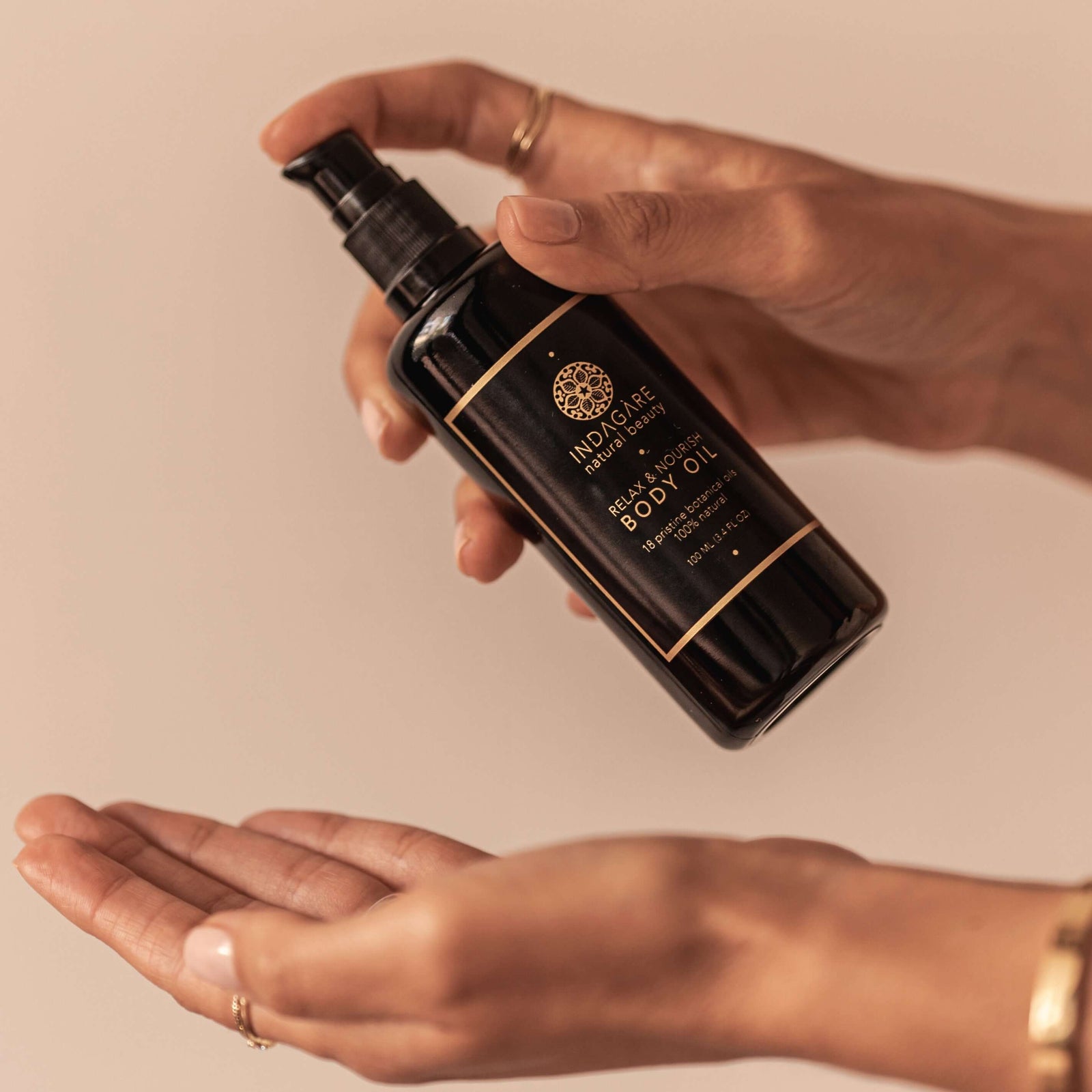 Woman pouring Repair and Nourish Organic Body Oil into her hand