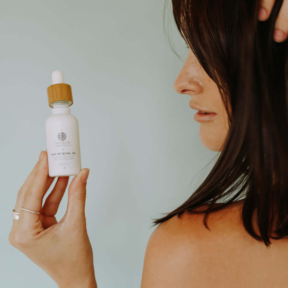 Woman holding up the Organic Hair Renewal Oil