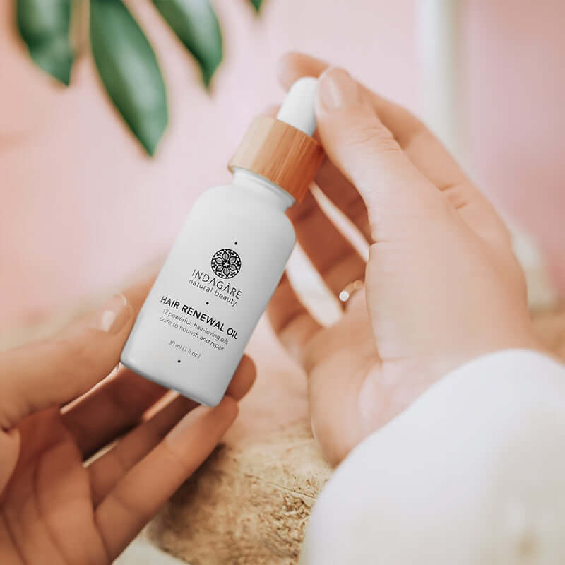 Woman's hands holding Indagare's Organic Hair Renewal Oil